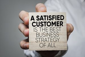 ITM vendors NJ, Hand holding block that reads "A satisfied customer is the best business strategy of all"