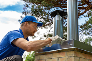 Chimney service Manasquan professional installing a tin chimney cap