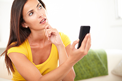 Woman looking questioningly at phone; Ocean County web design answers questions